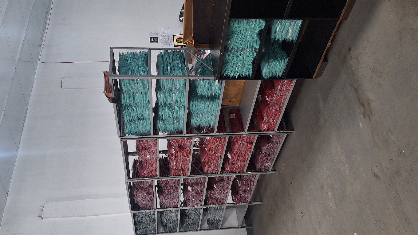 Roupas organizadas em prateleiras, prontas para expedição